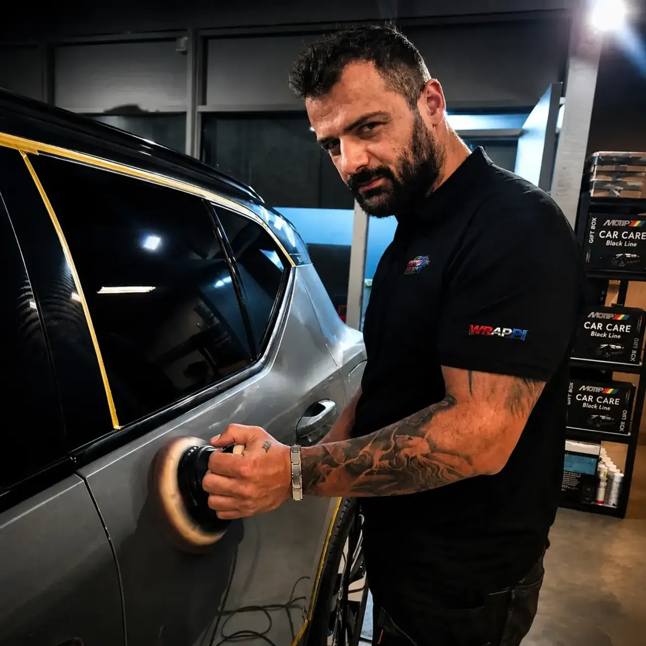 Machine polishing a grey car