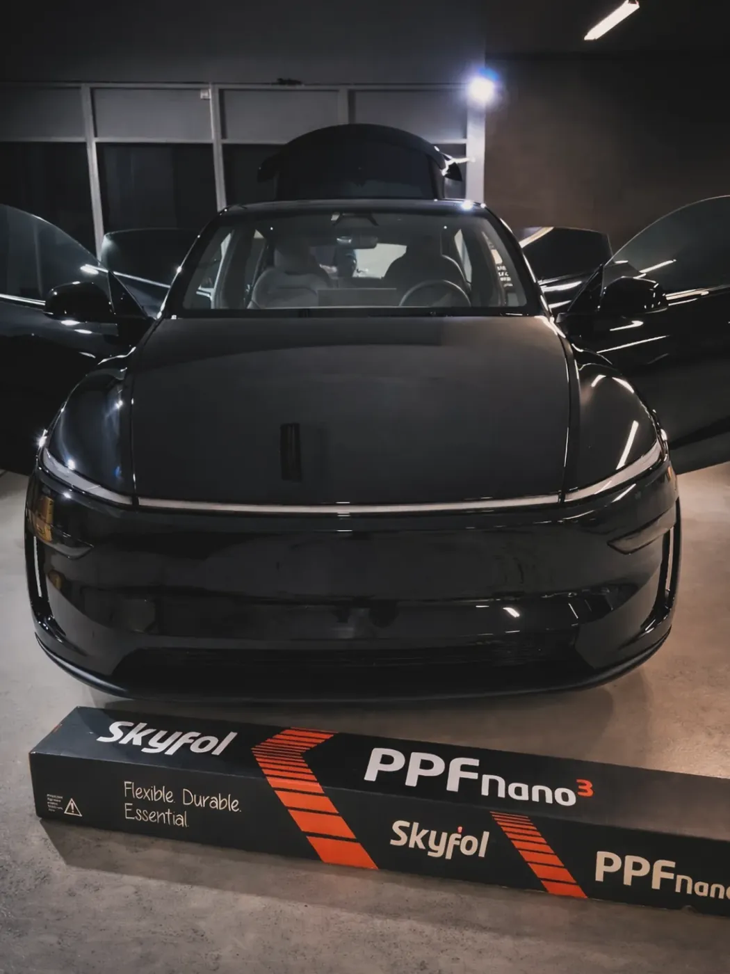 Black Tesla Model Y in the bay for PPF